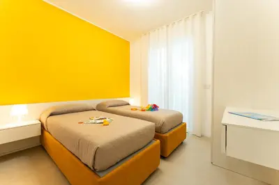 Letto o letti in una camera di Sun Village Residence con Piscina - Piazza Aurora - Adria Holiday Jesolo - FAMILY APARTMENTS