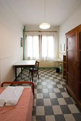 Letto o letti in una camera di Ostello Domus Civica